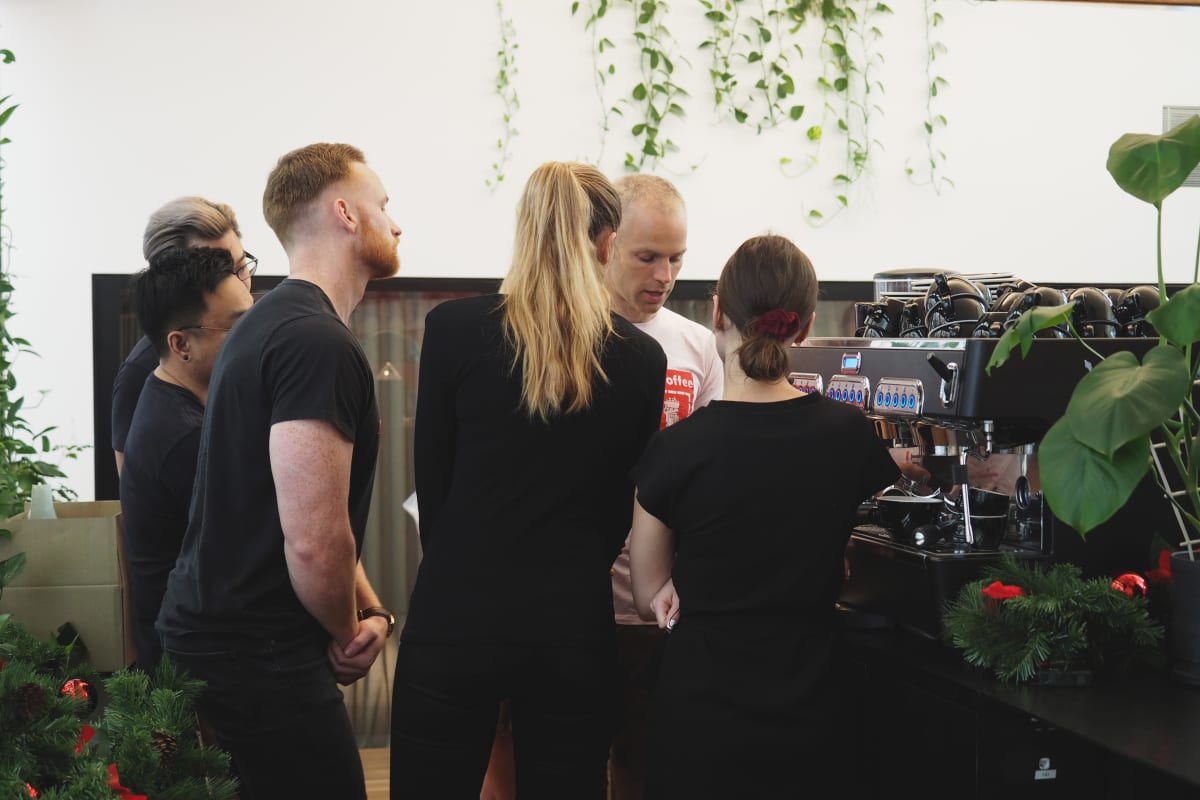 Reuben training the crew on latte art skills.