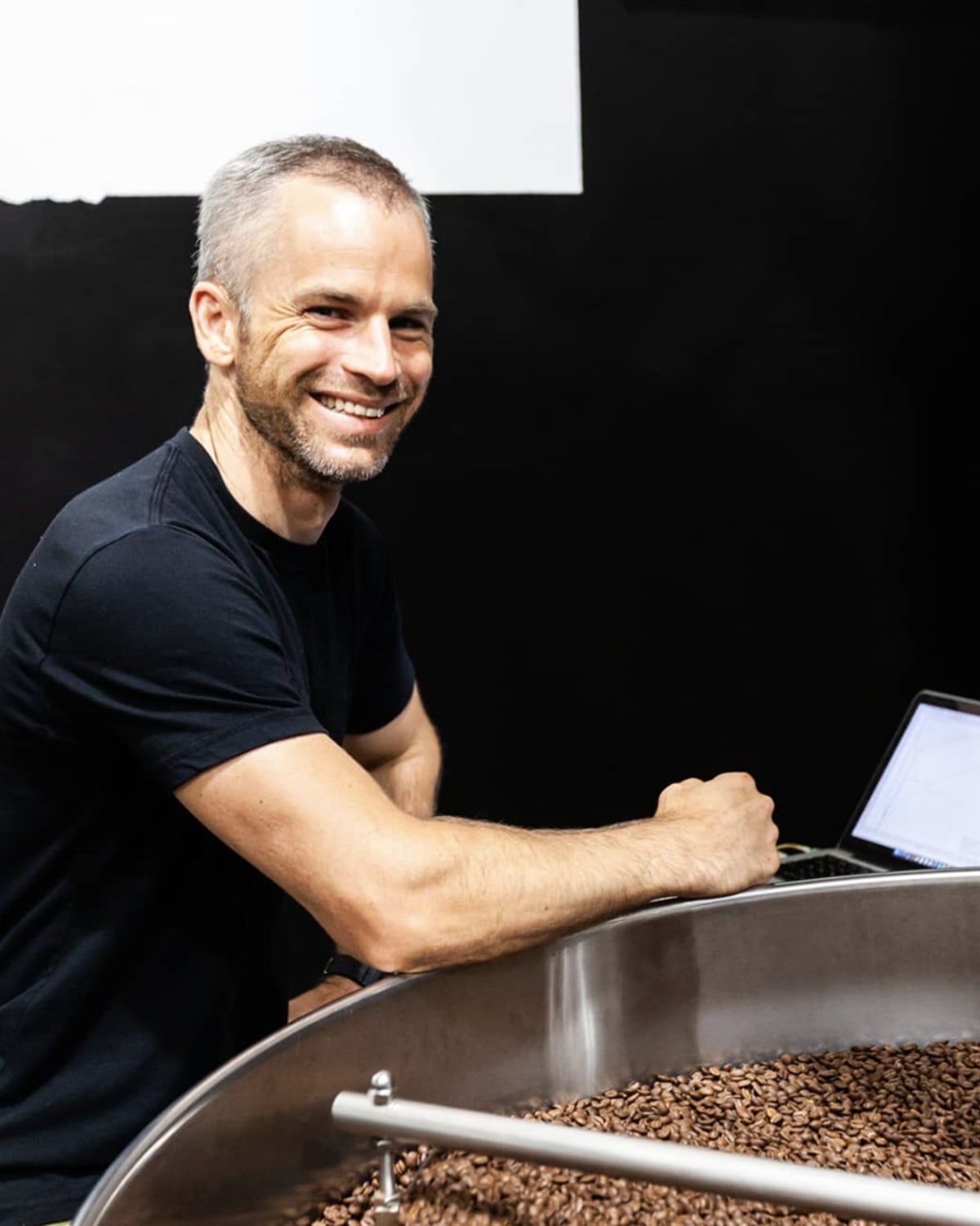 Reuben Mardan posing next to a coffee roaster